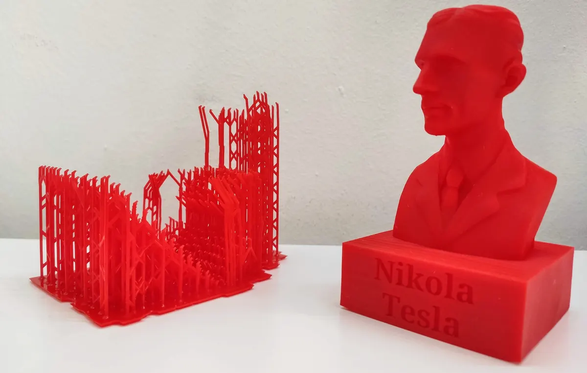 Piros 3D nyomtatott mellszobor talapzattal, mellette a nyomtatás után eltávolított alátámasztás